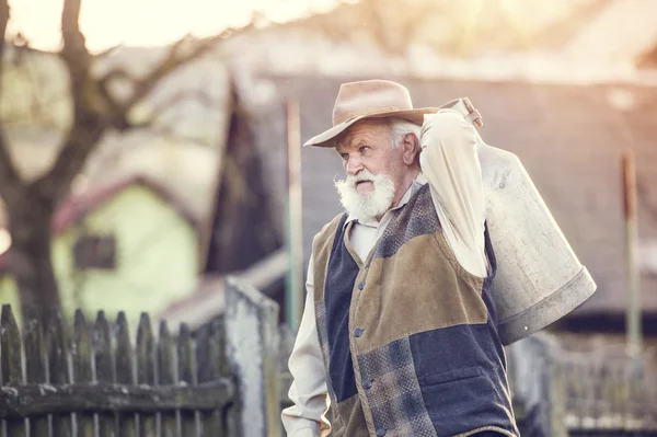 Agricultor que lleva hervidor de leche —  Fotos de Stock