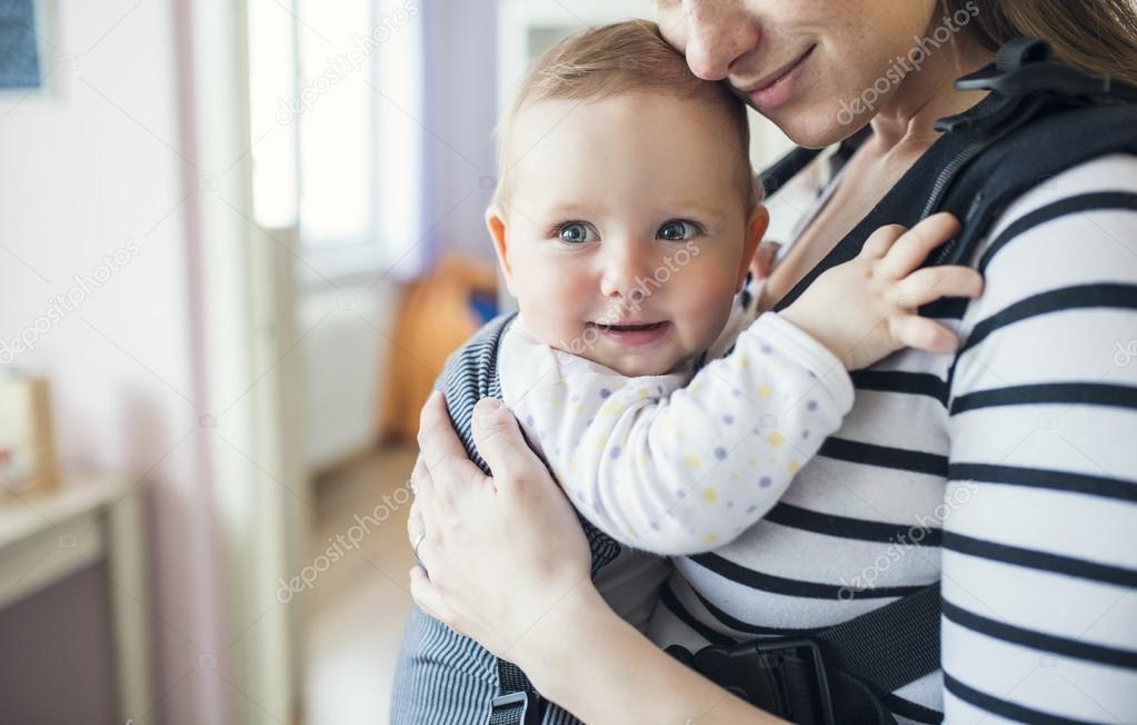 Mother with her daughter in baby carrier