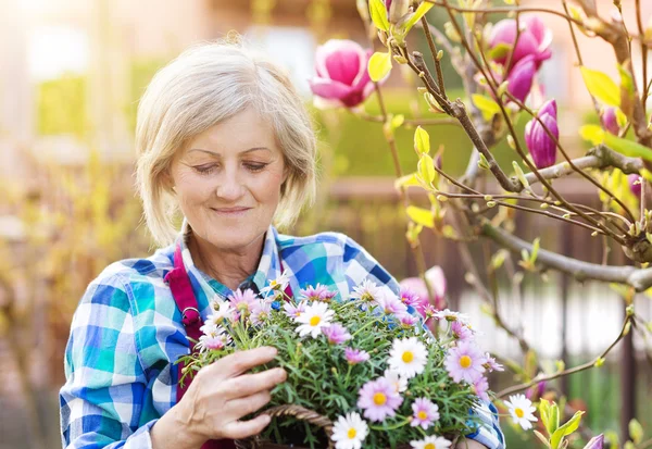 Mujer mayor con flores — Foto de Stock