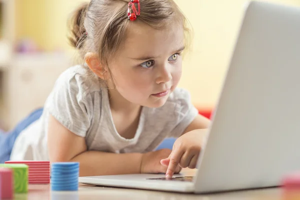 Little girl playing with notebook — Stock Photo, Image