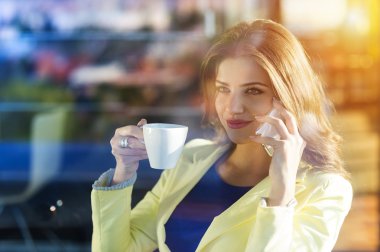 Kafede akıllı telefon kullanan kadın