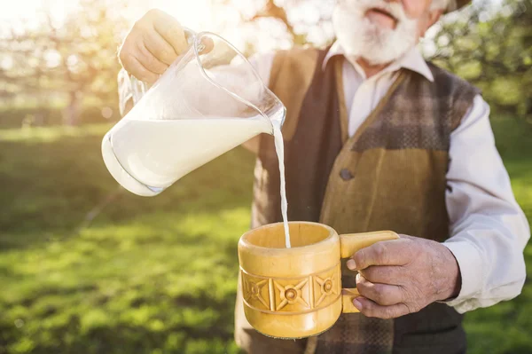 Agricoltore senior con brocca di latte — Foto Stock