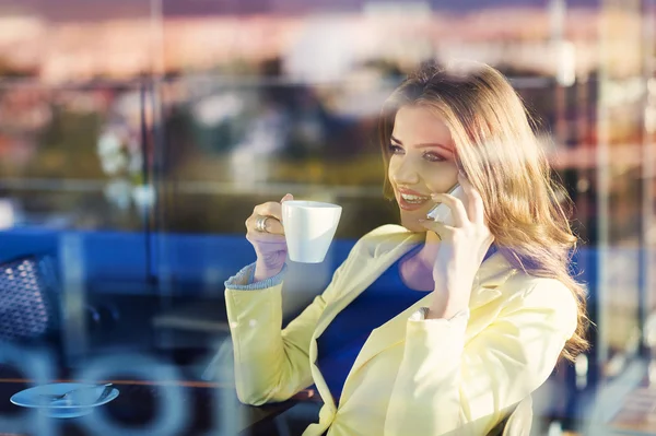 Vrouw met behulp van slimme telefoon in café — Stockfoto