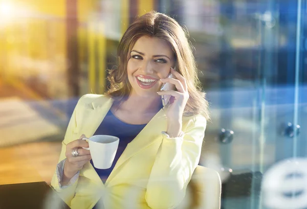 Vrouw met behulp van slimme telefoon in café — Stockfoto