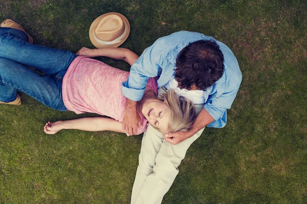 Ανώτερος ζευγάρι ξαπλωμένο σε ένα χόρτο — Φωτογραφία Αρχείου