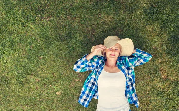 Senior vrouw liggen op een gras — Stockfoto