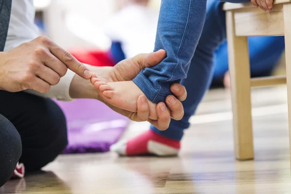 Father putting on socks to his  daughter — Stock Photo, Image