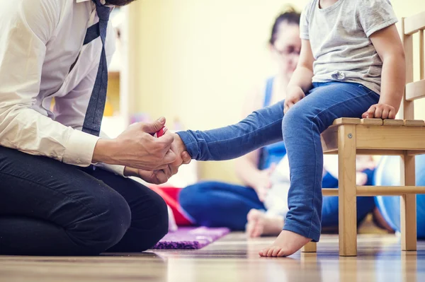 Father putting on socks to his  daughter — Stock Photo, Image