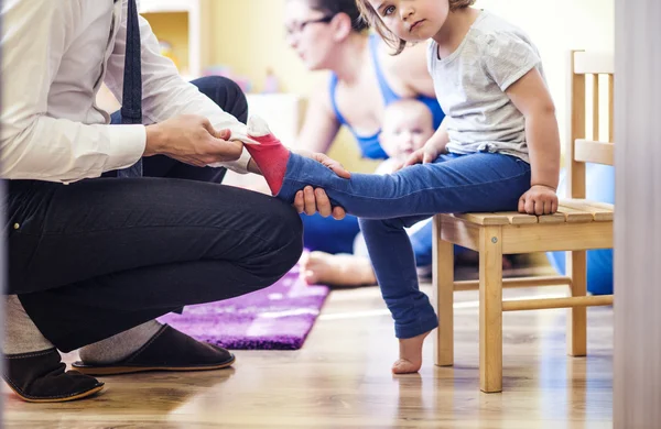 Père mettre des chaussettes à sa fille — Photo