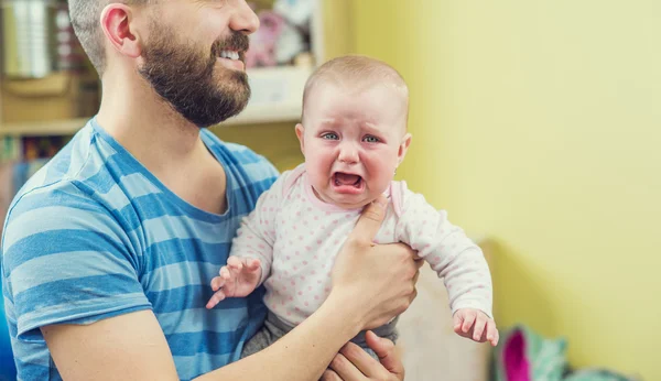 Pai segurando sua filhinha chorando — Fotografia de Stock