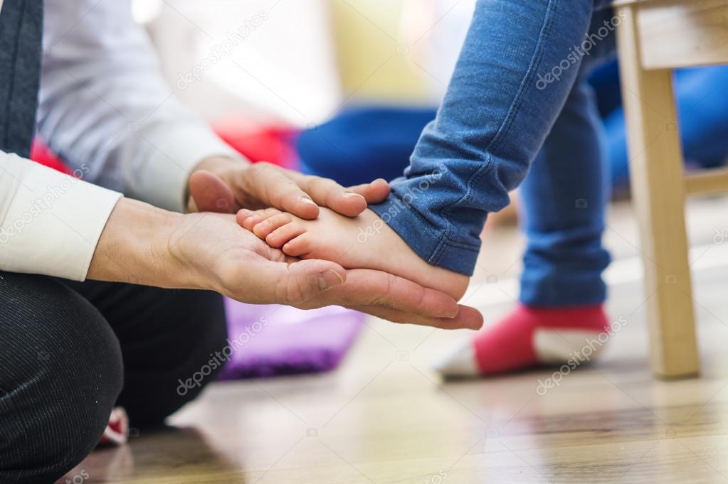 father putting on socks to his  daughter