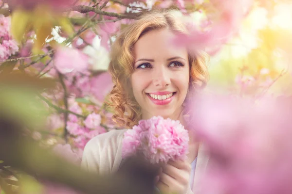 Kadının önünde çiçek açan bir ağaç — Stok fotoğraf