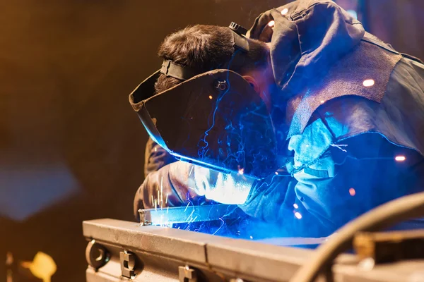 Homme avec masque de protection soudage dans une usine — Photo