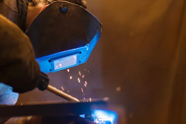 Man met beschermend masker lassen in een fabriek — Stockfoto