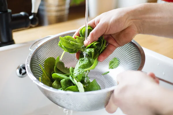 Man washing green salad leaves — Stockfoto