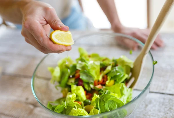 Homem preparando salada vegetal — Fotografia de Stock