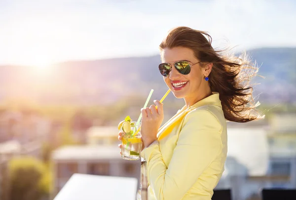 Woman with a drink on a terrace of a bar — Stockfoto