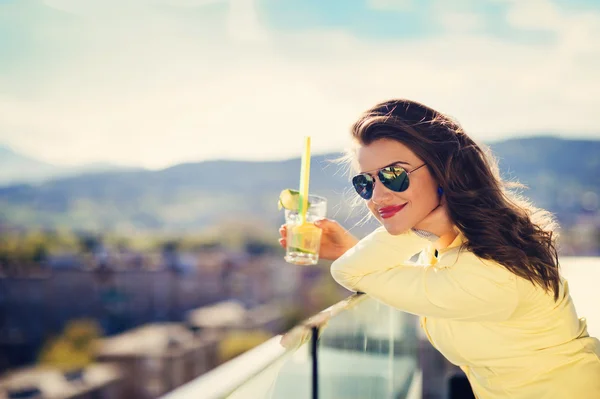Kvinne med en drink på en terrasse i en bar – stockfoto