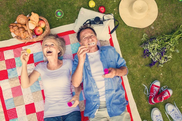 Beautiful seniors blowing bubbles — Stok fotoğraf