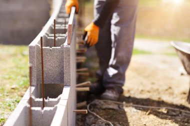 Bricklayer putting down row of bricks