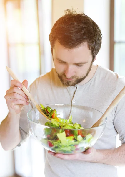 Young man with healthy vegetable salad — Stockfoto