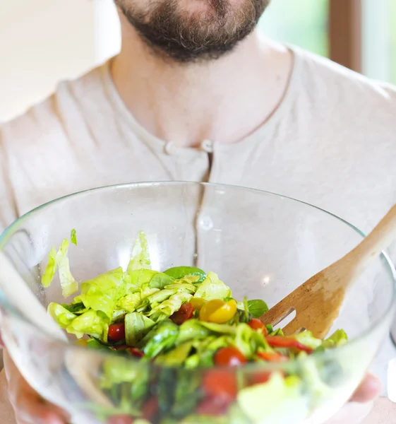 Young man with healthy vegetable salad — Stockfoto