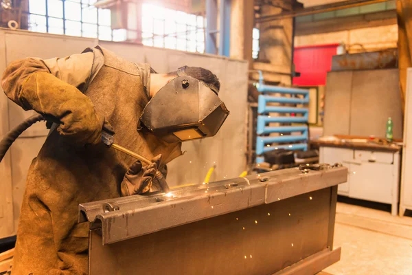 Mann mit Schutzmaske schweißt in Fabrik — Stockfoto