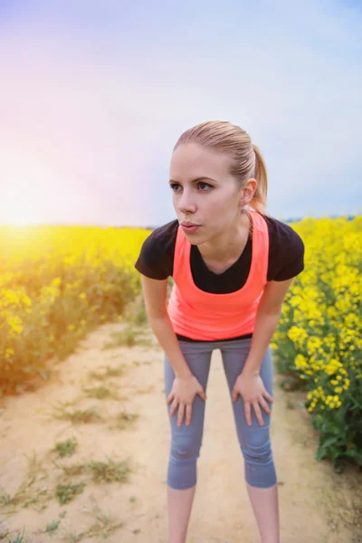 Runner resting in spring canola field — Stockfoto