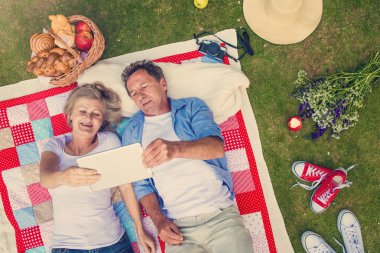 Seniors with notebook having a picnic