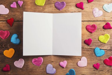 Empty sheet of paper and hearts on a floor.