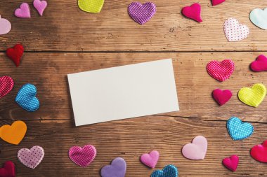 Empty sheet of paper and hearts on a floor.