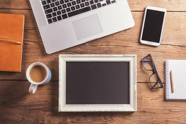 Office desk with blank photo frame. — Stockfoto