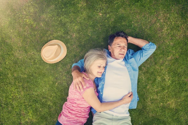 Красиві літні люди лежать на траві — стокове фото