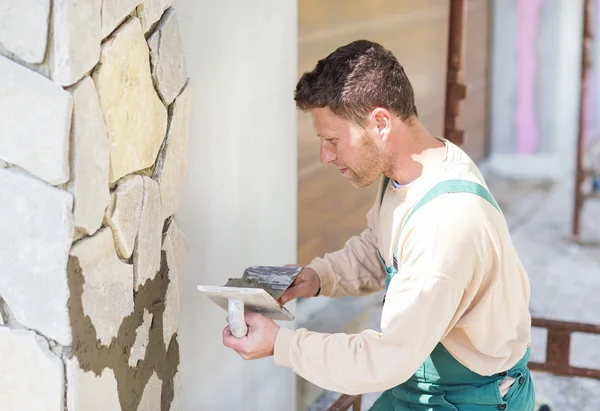 Mason poniendo piedras decorativas en una pared — Foto de Stock