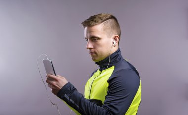 Akıllı telefon kullanan genç atlet.