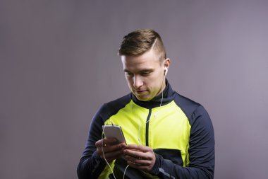 Akıllı telefon kullanan genç atlet.