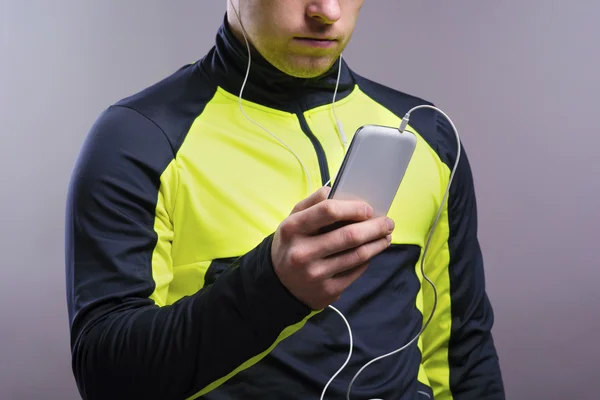 Unga löpare använder smart telefon. — Stockfoto