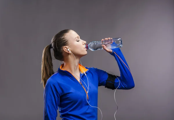 Beautiful runner drinks water — Stock Photo, Image