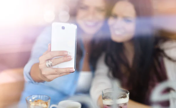 Two beautiful women taking selfie in cafe — Stock Photo, Image