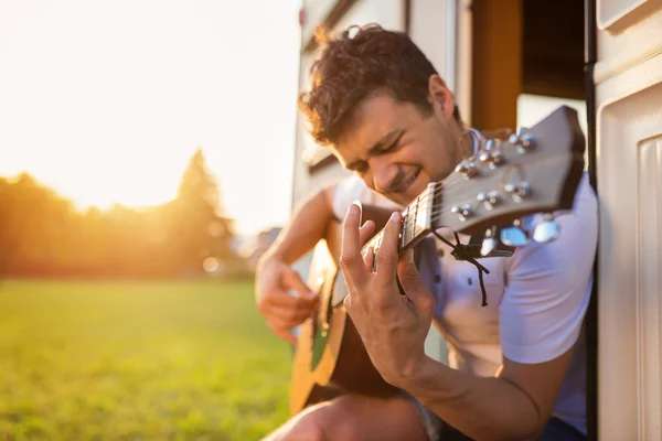 Красивый человек играет на гитаре — стоковое фото