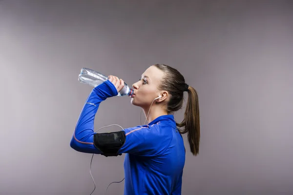 Beautiful runner drinks water — Stock Photo, Image