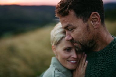 Gün batımında doğada romantik bir çiftin portresi. Hint Yazı.