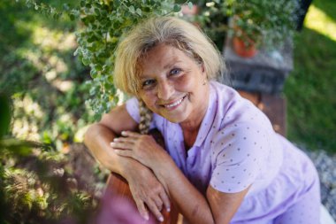 Yaşlı bir kadın için Selfacare anı, bahçede sakin bir zaman. Hint Yazı.