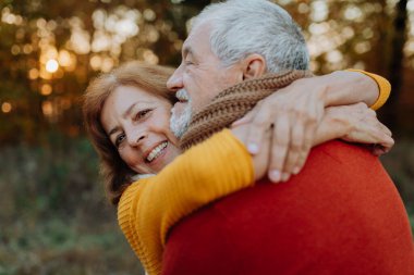 Son sınıf çifti arasındaki romantik an, sonbahar doğasının ortasında duruyor..