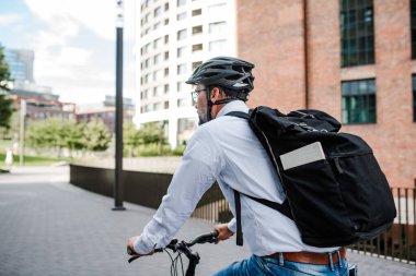 İşe bisikletle, işe giderken, sırt çantası ve kaskla..
