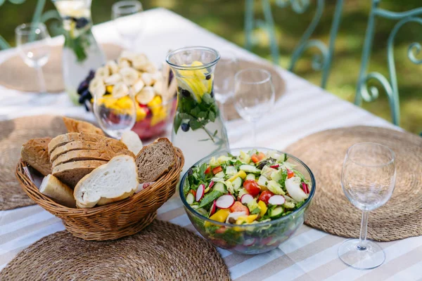 Dışarıda servis edilen taze meyve salatası ve ekmek. Bahçe partisi yemeği.
