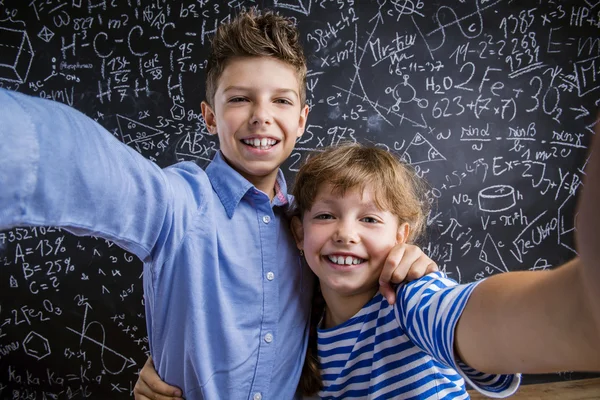 Schattige kleine jongen en meisje voor een grote bord. — Stockfoto