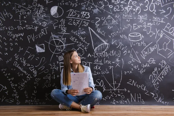 Beautiful young girl in front of blackboard — Stock Photo, Image