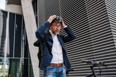 İş yerindeki banliyö yolcusu sürmeden önce kafasına kask takıyor.