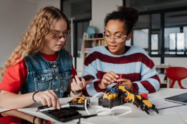 Robot projesinde çalışan lise öğrencileri, soruları cevaplamak için yapay zeka uygulamasını kullanıyorlar. STEM 'deki Kızlar.
